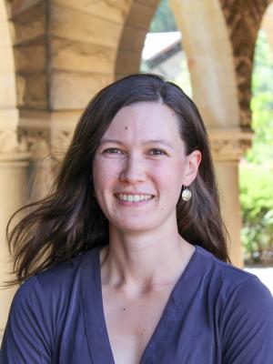 Headshot of Marissa Childs smiling outside in an arched outdoor walkway.